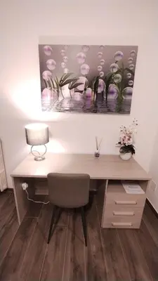 a desk with a lamp and a painting on the wall at Appartamento Fiore Roma San Pietro in Rome