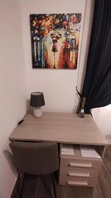 a desk with a chair and a painting on the wall at Appartamento Fiore Roma San Pietro in Rome