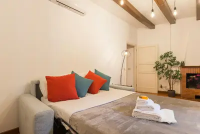 a room with a bed with orange and blue pillows at Campo de' Fiori appartamento via di Grotta Pinta in Rome