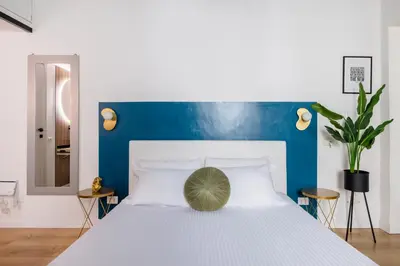 a bedroom with a white bed with a blue headboard at LABICANA Apt - Colosseum in Rome