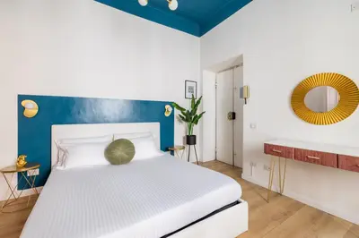 a bedroom with a white bed and blue walls at LABICANA Apt - Colosseum in Rome