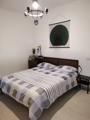 a bedroom with a bed and a chandelier at OFFICINALE Rome Apartment, Pineta Sacchetti in Rome
