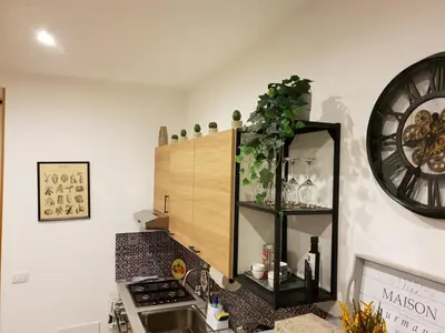 a kitchen with a cabinet and a clock on the wall at OFFICINALE Rome Apartment, Pineta Sacchetti in Rome