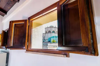 a window in a kitchen with a building in the background at Magikrooms Muse in Rome