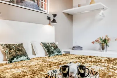 a bed with two cups and a tray on it at TH Trastevere Luxury-S.Cosimato 2bd-2bt in Rome