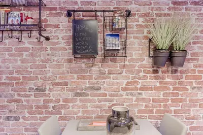 a brick wall with a table and chairs and a chalkboard at TH Trastevere Luxury-S.Cosimato 2bd-2bt in Rome
