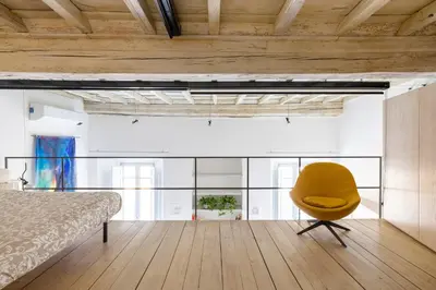 a bedroom with a bed and a yellow chair at Ottavia al Foro - Luxury Property in Rome