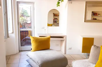 a living room with a yellow pillow on a chair at Ottavia al Foro - Luxury Property in Rome