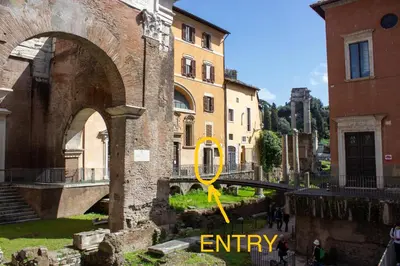 an old building with a yellow arrow in a city at Ottavia al Foro - Luxury Property in Rome