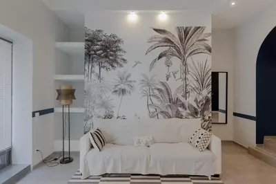 a white couch in a living room with a palm tree mural at Navona Harmony Apartments in Rome
