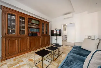 a living room with a couch and a book shelf at Vatican Dome View Apartment in Rome