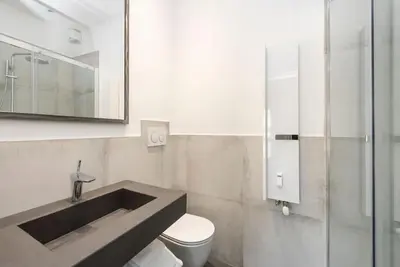 a bathroom with a sink and a toilet and a mirror at Vatican Dome View Apartment in Rome