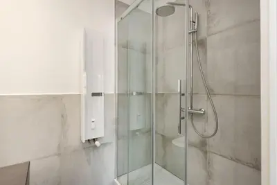a shower with a glass door in a bathroom at Vatican Dome View Apartment in Rome