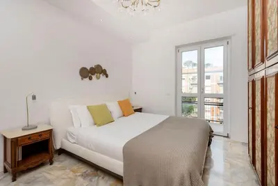 a white bedroom with a bed and a window at Vatican Dome View Apartment in Rome