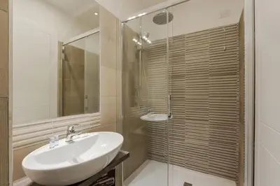 a bathroom with a sink and a glass shower at Le Stanze di Rinaldo in Rome