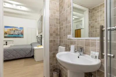 a bathroom with a sink and a mirror and a bed at Le Stanze di Rinaldo in Rome