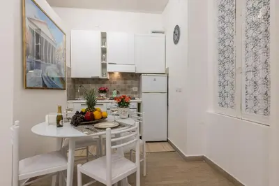 a white kitchen with a white table and chairs at Le Stanze di Rinaldo in Rome