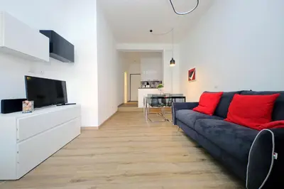 a living room with a blue couch and red pillows at 4BNB - Cozy Albornoz Flat in Rome