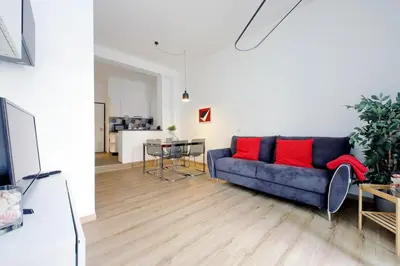 a living room with a blue couch and red pillows at 4BNB - Cozy Albornoz Flat in Rome