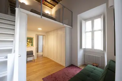 a living room with a green couch and a window at Charm and Style by Campo de Fiori in Rome