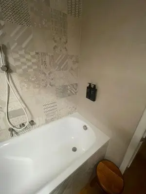 a white bath tub in a bathroom with a wooden stool at Charm and Style by Campo de Fiori in Rome