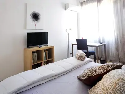 a room with a bed with a television and a desk at 