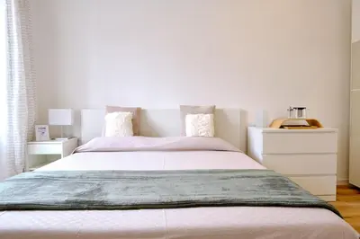 a bedroom with a large bed and a white dresser at Remuria Domus in Rome