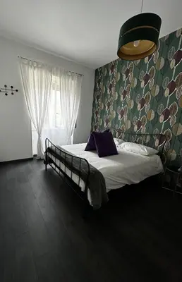 a bedroom with a bed and a large window at DOMUS H501 in Rome