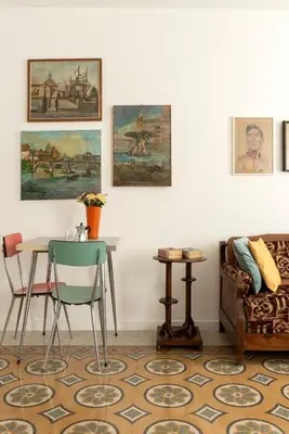a living room with a table and chairs and paintings at Residenza Urbana in Rome