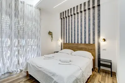 a bedroom with a white bed and a large window at VATICANDREAM GUEST HOUSE in Rome