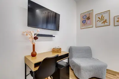 a desk with a chair and a television on a wall at VATICANDREAM GUEST HOUSE in Rome