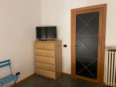 a room with a door and a tv and a dresser at Your comfy Home in Rome