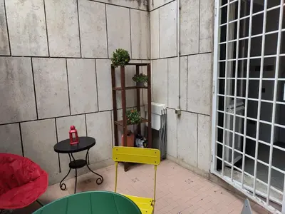 a table and a yellow chair in a room with a table and window at Your comfy Home in Rome