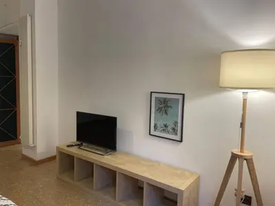 a living room with a table with a tv on a wall at Your comfy Home in Rome