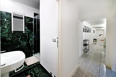 a white bathroom with a sink and a shower at St Peter Regal Apartment in Rome