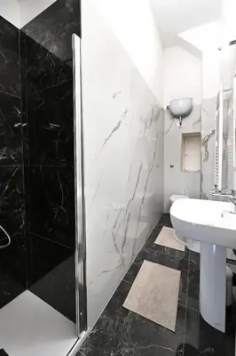 a bathroom with a sink and a shower at St Peter Regal Apartment in Rome
