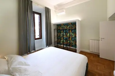 a bedroom with a white bed and a window at St Peter Regal Apartment in Rome
