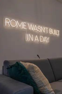 a sign that says rome wasnt built inlaw above a couch at Vintage Cipro Apartment in Rome