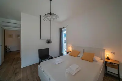 a bedroom with a white bed and a television at Vintage Cipro Apartment in Rome