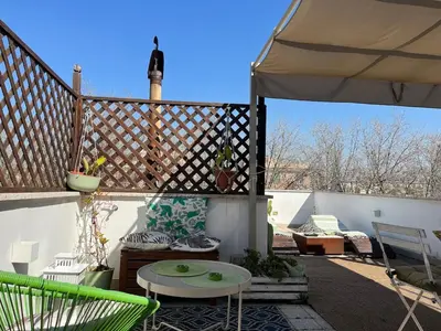a patio with an umbrella and a table and chairs at Monteverde Double Terrace Penthouse in Rome