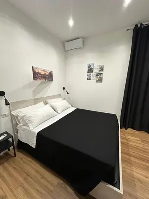 a bedroom with a black and white bed and a television at Moderno appartamento Cornelia-San Pietro con Giardino in Rome