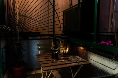 a wooden table with two glasses on a balcony at C&Y Apartments - Roma Vaticano St Peter - Luxe Penthouse Flat in Rome