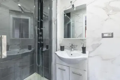 a white bathroom with a sink and a shower at Colosseo Roma color's in Rome