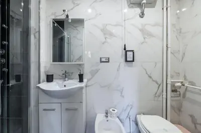 a white bathroom with a sink and a toilet at Colosseo Roma color's in Rome