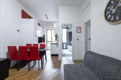 a kitchen and dining room with a table and red chairs at Colosseo Roma color's in Rome