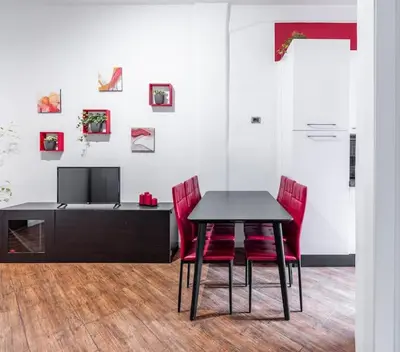 a dining room with a table and red chairs at Colosseo Roma color's in Rome