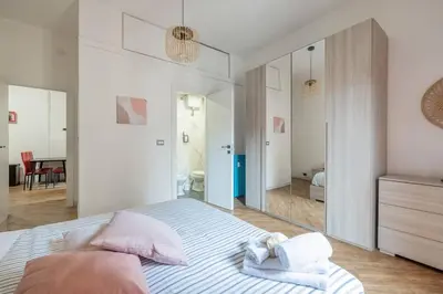 a bedroom with a bed with towels and a mirror at Colosseo Roma color's in Rome