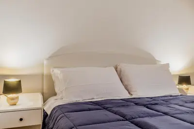 a bed with a blue comforter and white pillows at MARCONI31Eredia in Rome