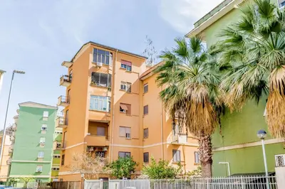 a building with palm trees in front of it at MARCONI31Eredia in Rome