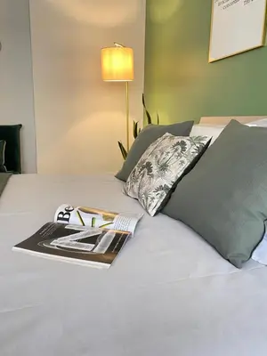 a book on a bed with a pillow and a magazine at San Pietro Sweet RHome in Rome